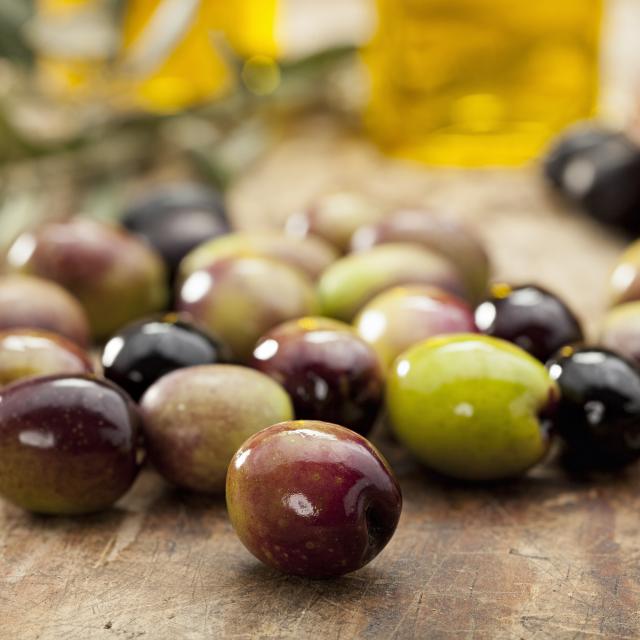 Green and black olives on old table.