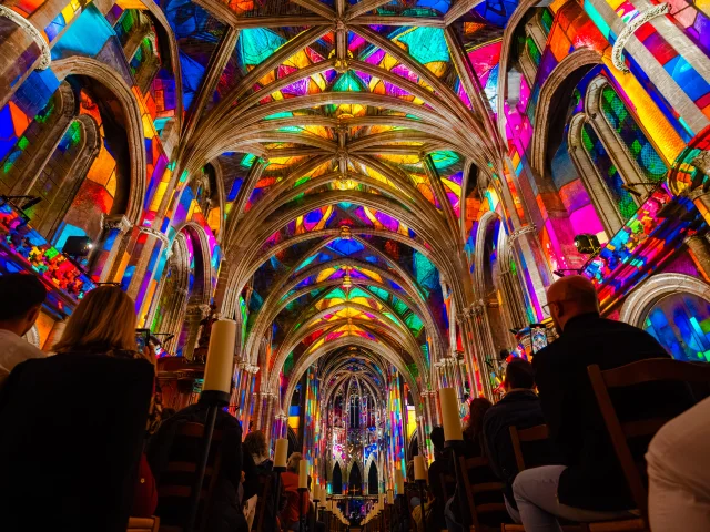 Spectacle lumineux Luminiscence dans la basilique Notre-Dame de Nice, avec projections multicolores sur les voûtes gothiques et un public émerveillé